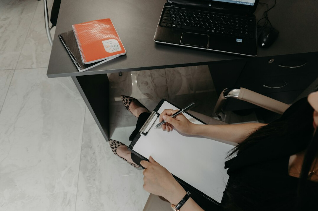 person sorting green folders on desk