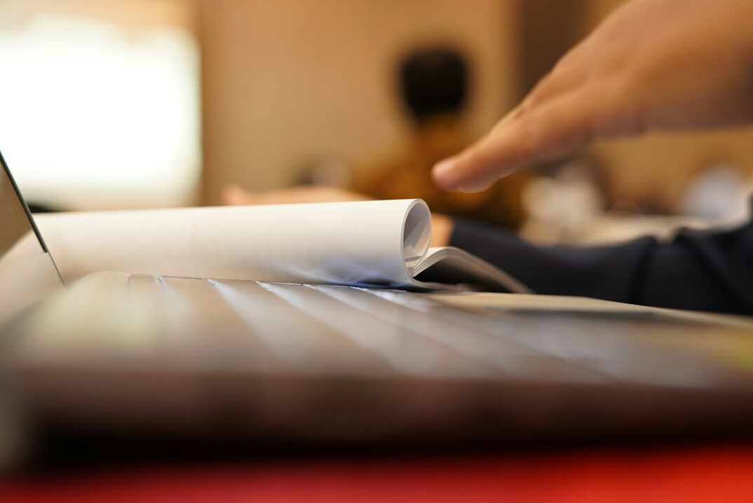 person using laptop with documents